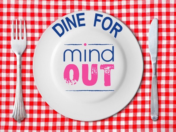 a plate on a red check table cloth with "dine for mindout" written on it in coloured writing