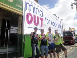 volunteers and staff beside the MindOut bus before it sets off for the parade