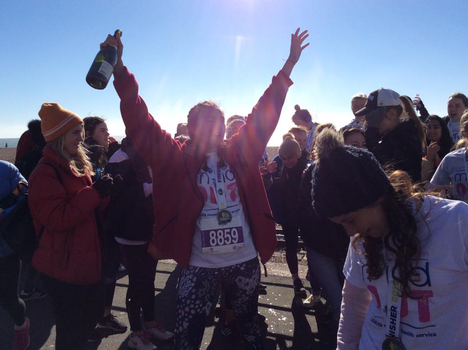 a runner cheering with a bottle of champagne