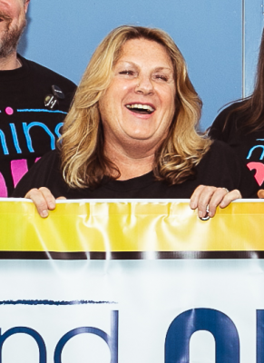 Photo of Dawn laughing and holding a banner