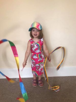 ella ray with a rainbow hat and rainbow streamers