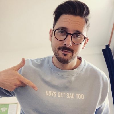 Charlie, a MindOur Volunteer, wearing a T shirt with the slogan Boys Get Sad Too