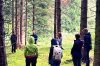 Group of people standing in a circle in a forested environment