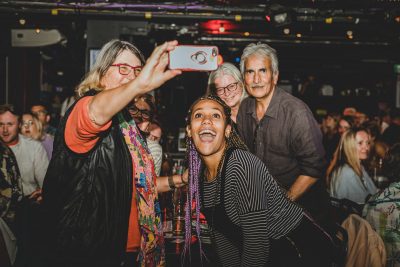 Kate Cheka, smiling and taking selfies with four others after her stand up performance