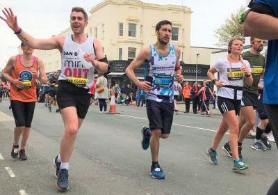 dan running through brighton waving