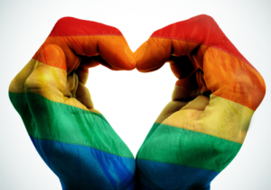 to rainbow coloured hands creating a heart shape