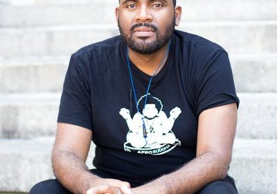 Lama Rod Owens seated on some steps