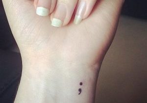 a tattoo on the wrist of a semi colon